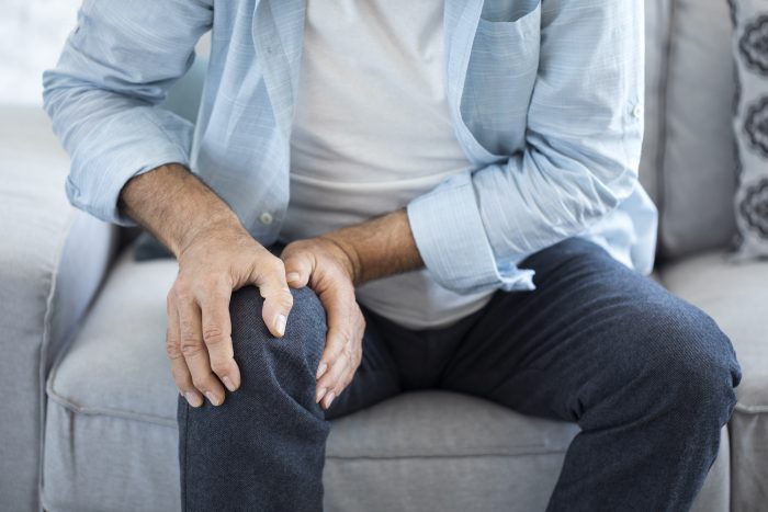 a man holding his knee in discomfort